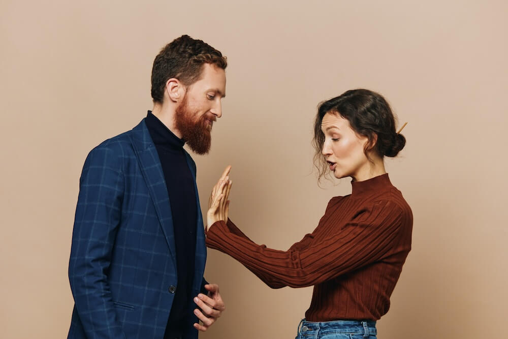 Kobieta odpychająca od siebie natarczywego mężczyznę