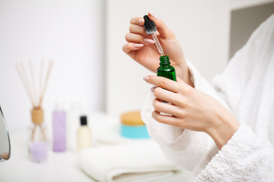 Buteleczka z drzewa herbacianego trzymana w dłoniach kobiety