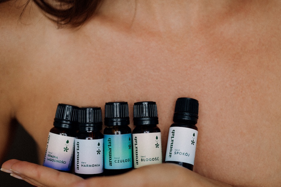 Kobieta trzymająca na dłoni różne olejki eteryczne