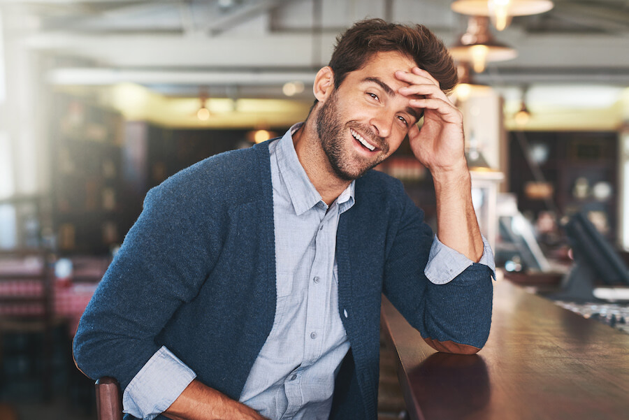 Uśmiechnięty facet siedzący w pubie
