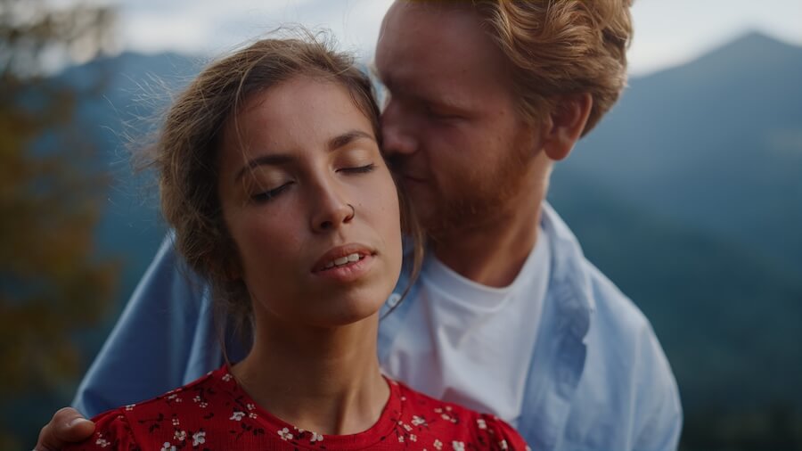 Kobieta całowana przez faceta w ucho