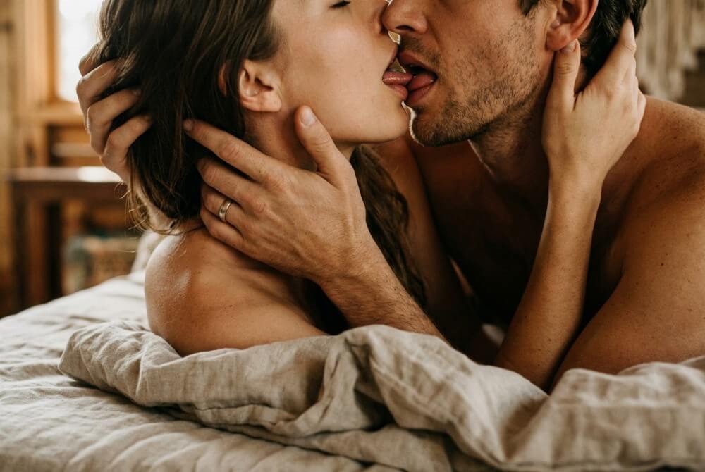 Para w namiętnym pocałunku francuskim, ciepłe światło, dłoń na policzku