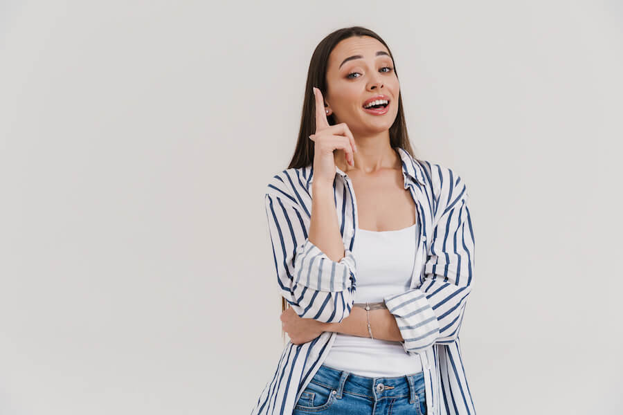 Uśmiechnięta kobieta z uniesionym palcem