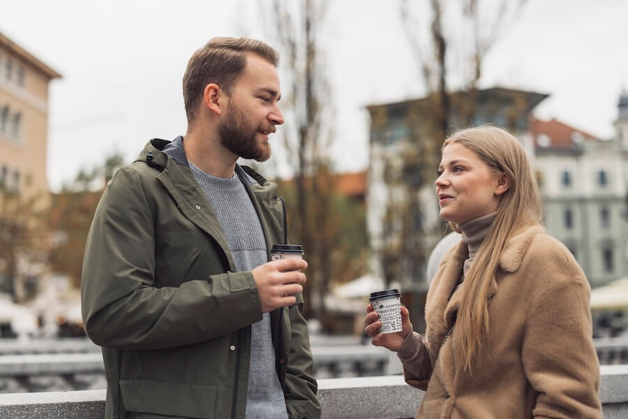 Mężczyzna z zarostem podczas rozmowy przy wspólnej kawie z kobietą