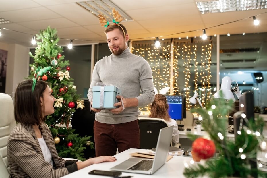 Mężczyzna wręczający kobiecie w biurze prezent