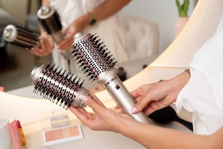 Kobieta trzymająca suszarką lokówkę z wymienną końcówka