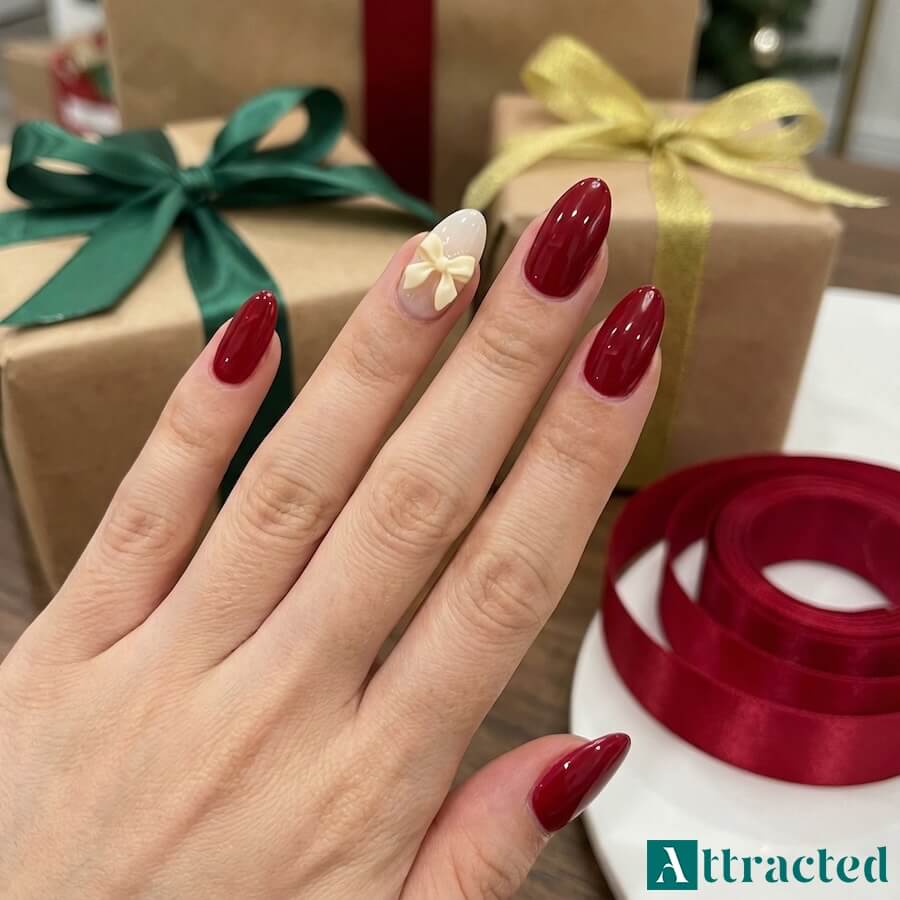 Kokardki na jednym paznokciu, czyli bow nails, często na mlecznej lub czerwonej bazie