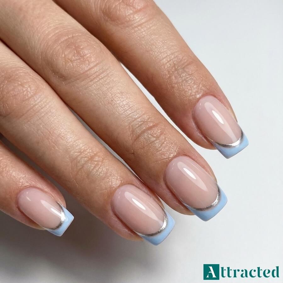 Zbliżenie jednej dłoni z kwadratowymi paznokciami double french w błękicie i srebrze, na jasnym neutralnym tle