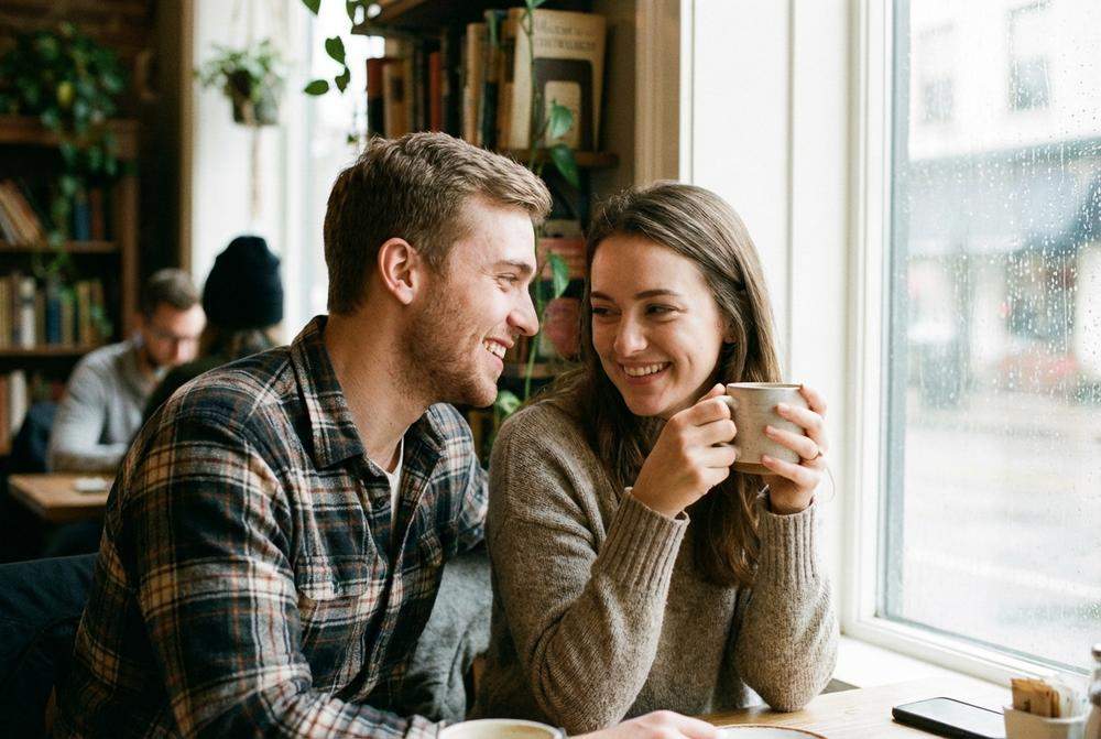 Mężczyzna uśmiecha się do kobiety w kawiarni