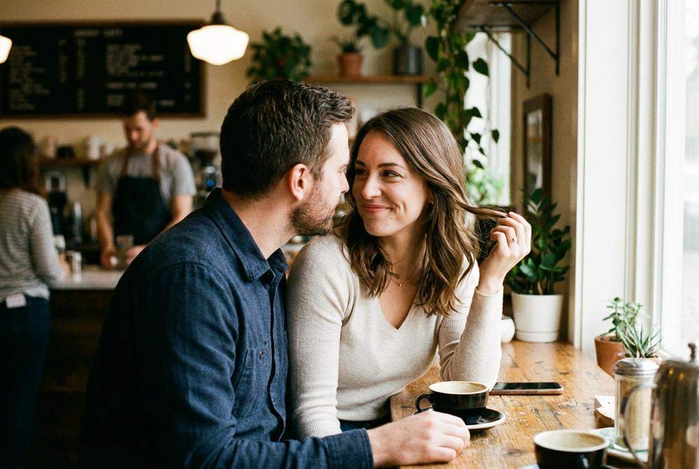 Para w kawiarni utrzymująca kontakt wzrokowy oznaki iskrzenia