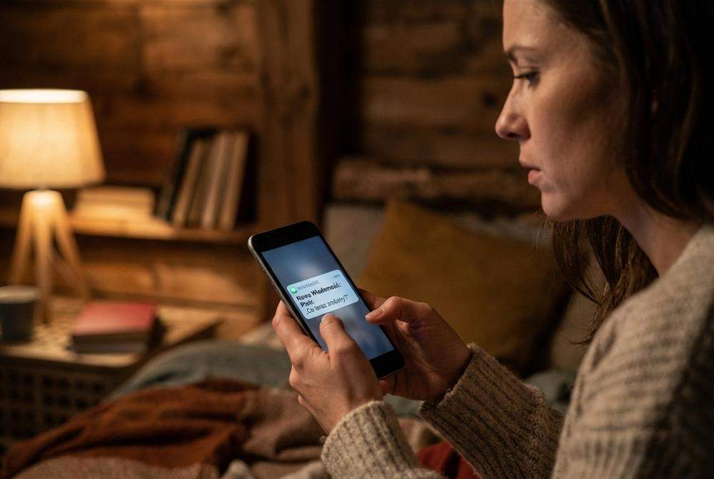 Kobieta otrzymująca sms od żonatego mężczyzny w nocy