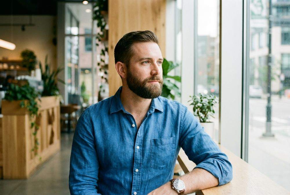 Zamyślony mężczyzna w stylu smart casual symbolizujący dojrzałość emocjonalną