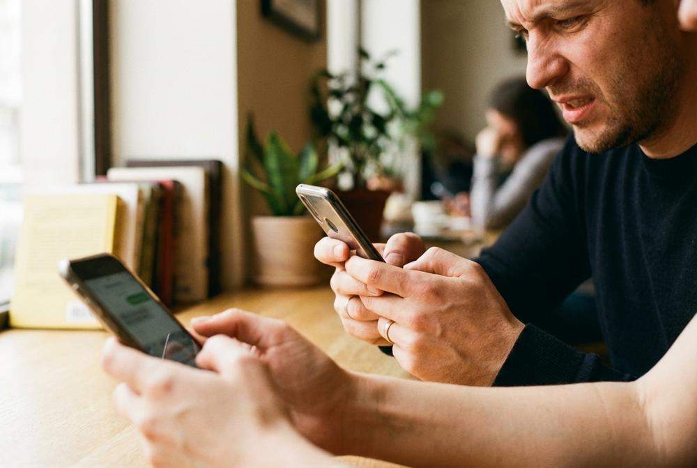 żonaty mężczyzna pisze wiadomość na telefonie z obrączką na palcu